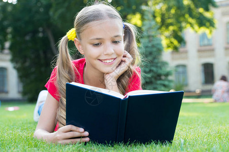 女学生一边放松绿色草坪一边读故事可爱的学生喜欢阅读上学时间适合孩子们的有趣故事愉快地学习是时候讲好故事了小背景图片