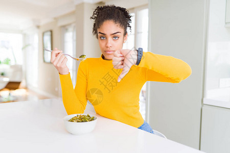 年轻非裔美国妇女吃健康的绿色蔬菜图片