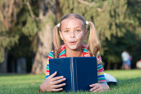 可爱的书虫上学时间培养积极和取得成就的有爱心的学习者小孩看书女学生阅读故事放松绿色草坪可爱的图片