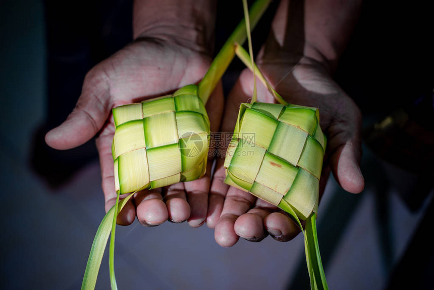 Ketupat是一种用包装在一个钻石形状的圆形棕榈叶袋容器中的大米制成的面料图片