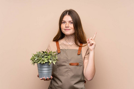 乌克兰十几岁的园丁女孩拿着一株用食指着的植物图片
