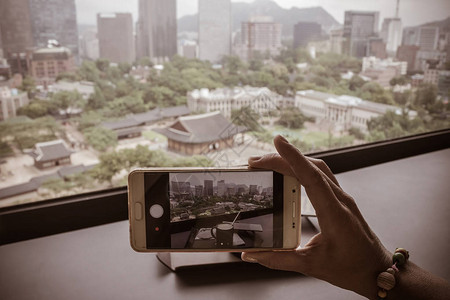 一个女孩用智能手机拍下首尔的照片图片