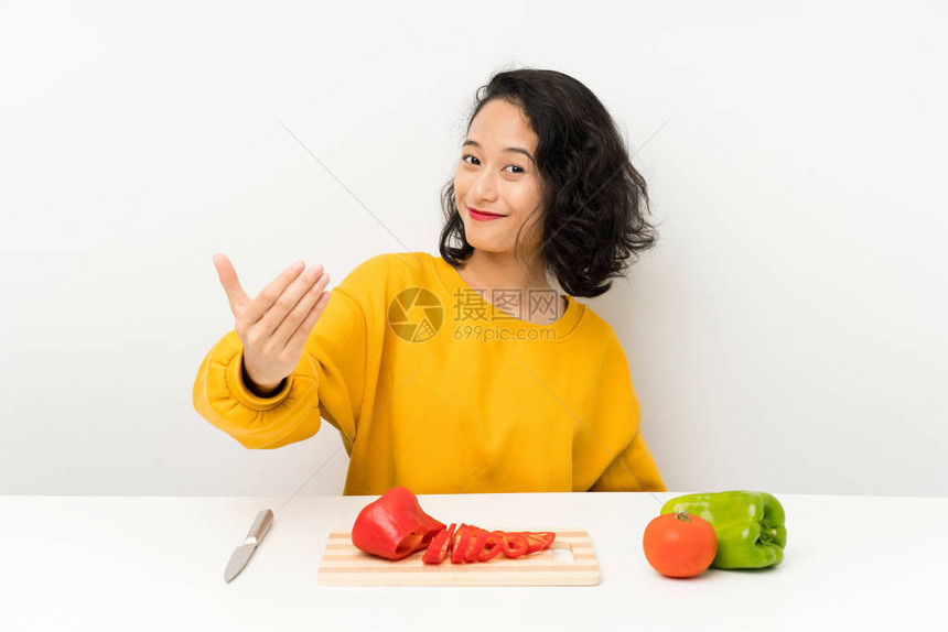 有蔬菜的年青亚洲女孩在邀请来的桌图片