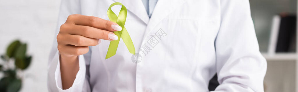 持有绿色认识丝带心理健康概念网站头版的医生图片