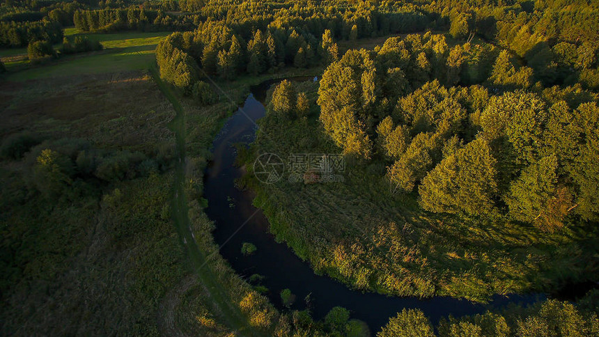 波兰中部的小河在绿草原和森林之间图片