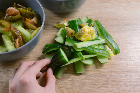 用于堆肥和女手的有机蔬菜下脚料在木材背景上烹饪沙拉后的食物浪费零废图片