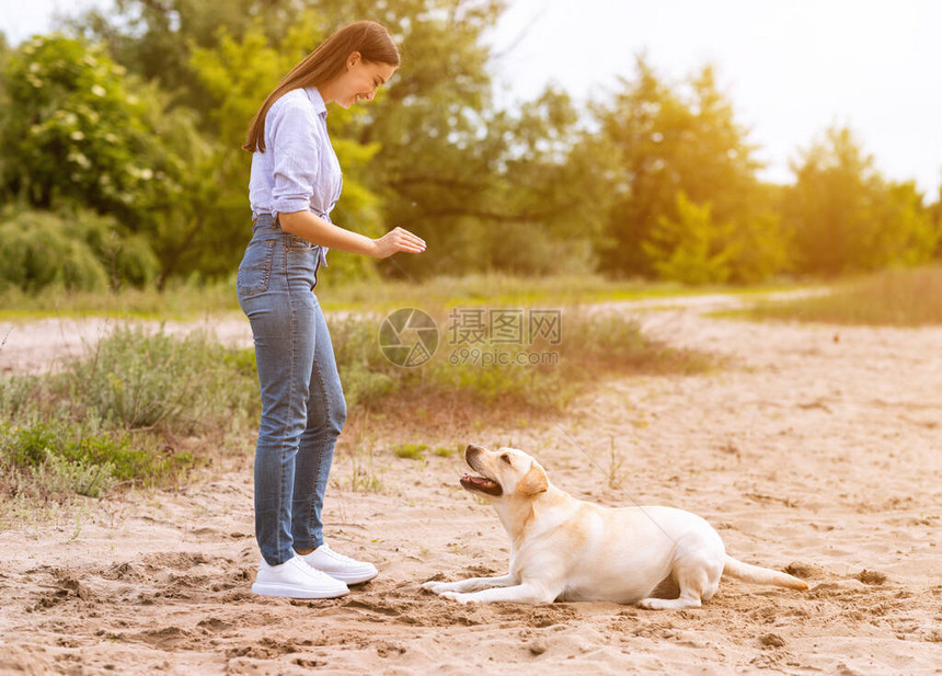 美丽的女人训练她的狗图片