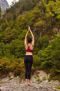 大自然中的瑜伽课独自参加运动的概念社会排斥一个女人在岩石上做瑜伽背景图片
