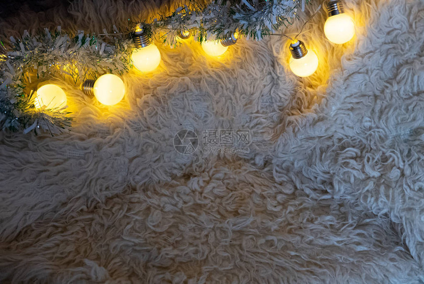 白色地毯上的圣诞花环灯图片