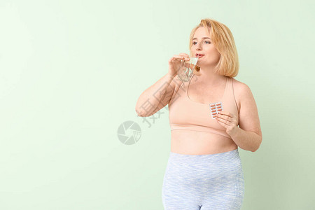 彩色背景上有减肥药和水的女人图片