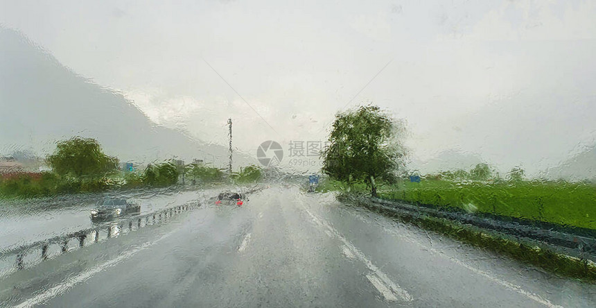 公路上被大雨覆盖的高速公路上的模糊卡车挡风玻璃图片