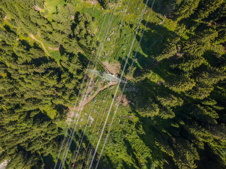 通过瑞士高山森林对电线进行空中观测图片