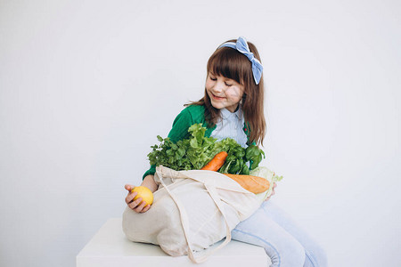 小女孩拿着带有蔬菜的纺织食品袋零废物概念包免费食品购物有机水果和蔬菜图片