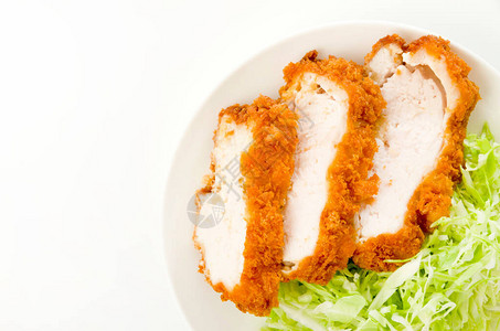 面包屑鸡胸肉配白菜丝在白色背景上的白色盘子图片