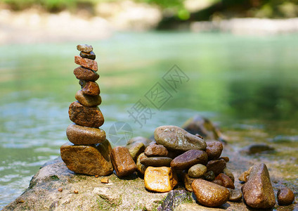在岩石和溪水中分类或堆叠鹅卵石塔或金字塔图片