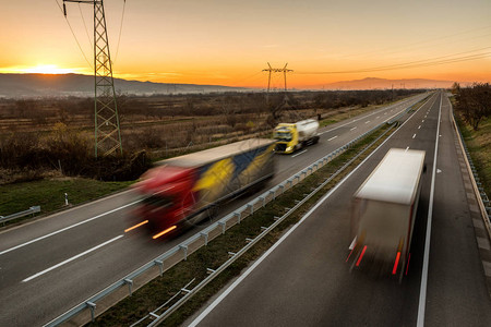 送货卡车和汽车在高速公路上高速行驶图片