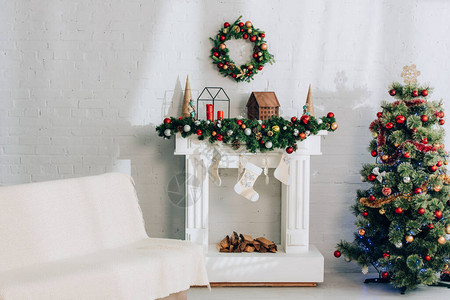 索法在壁炉附近带毯子的沙发带有圣诞丝图片