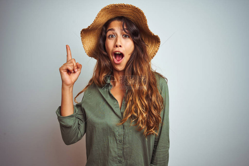 年轻漂亮的女人在度假时穿着绿色衬衫和帽子图片