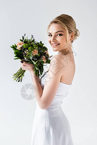 穿着优雅结婚礼服的幸福新娘拿着白图片