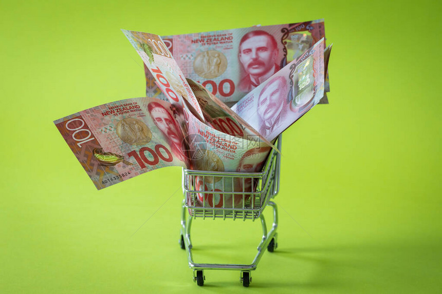 有新西兰百元钞票的微型购物车购物的概念图片