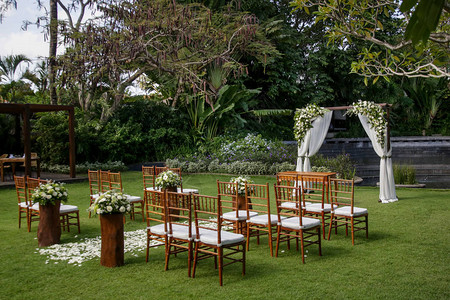 在热带花园木椅和用白色花朵装饰的简单观舞厅举行美丽浪图片