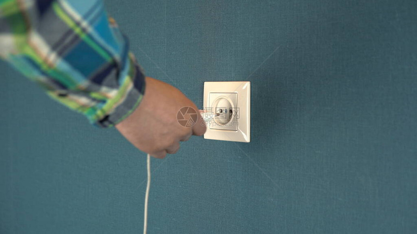 一个男人将手机充电器插入墙上的插座墙上的玫瑰花饰有深蓝色壁纸4k图片