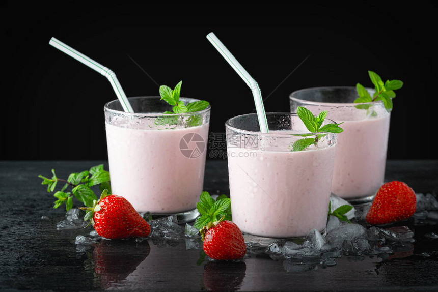桌上有一杯新鲜草莓奶昔冰沙或奶昔和新鲜草莓多汁水果的健康食图片