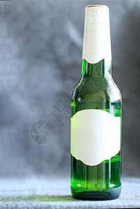 绿色啤酒瓶在布料背景上图片