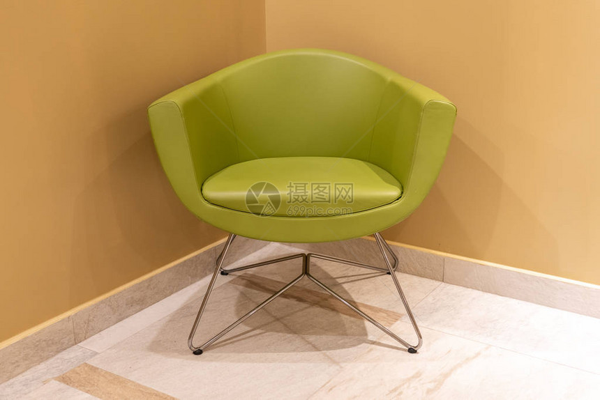 现代室内的绿色皮椅站在角落里图片