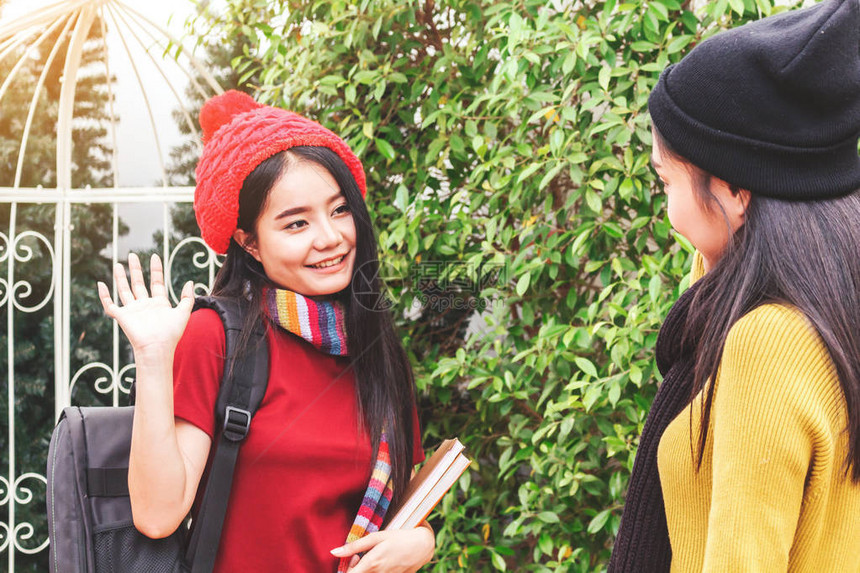 女学生在公园友谊和团结概念中与朋友打招呼图片