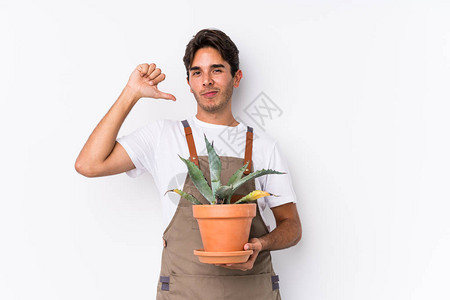 年轻caucasian园丁男子持有一个孤立的植物图片