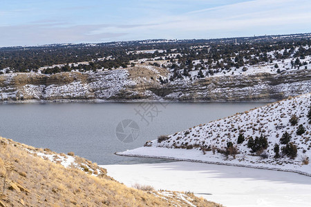 冰冻的湖泊和雪覆盖着梦幻般的冬季仙境景色中的山丘图片