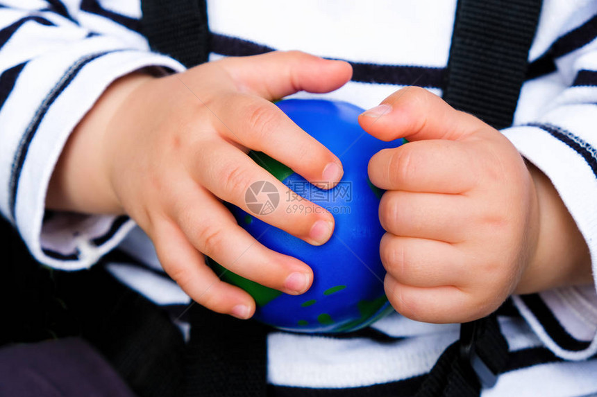 婴儿手中的球形地球仪孩子正在玩地球仪关闭图片