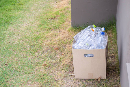 棕色回收垃圾箱中的塑料瓶图片