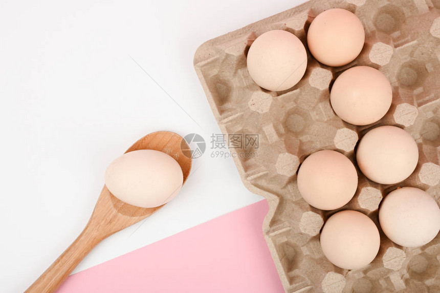 木勺上的鸡蛋白色和粉红色背景上的一盘鸡蛋带睾丸的生态托盘简约趋势图片