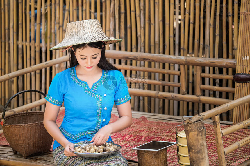 穿着蓝色传统泰国式服装的女孩正在收集蘑菇图片