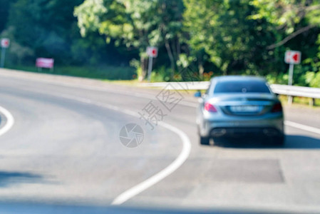 银色汽车在现代公路上左转的模糊图背景图片