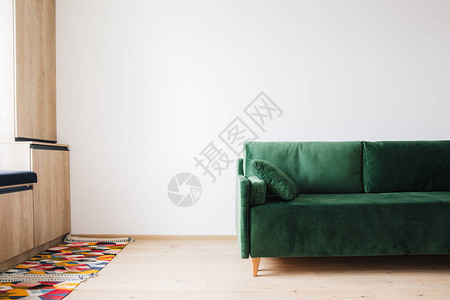 绿色沙发地板和木柜上有在彩色地毯附近图片