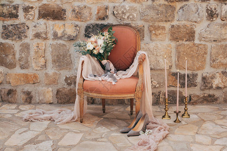 白色和奶油色玫瑰桉树枝粉色和灰色丝带在扶手椅上的新娘花束图片