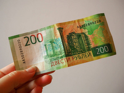 女人的手拿着一张新的俄罗斯银行两百卢布钞票钞票的反面俄罗斯纸图片