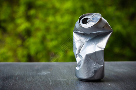 酒底下面的压碎铝银罐背景图片