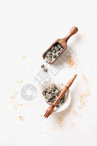 勺子和小盘子上用木制接板在白大理石背景上捡到的盐味披肩图片