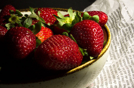 报纸上桌子上的红草莓图片