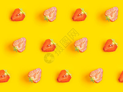 成熟的多汁草莓在明亮黄色背景下被切成两半的对角图案图片