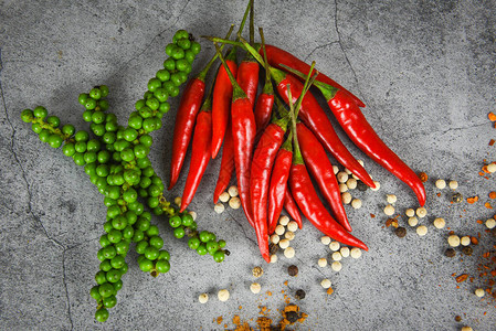 深色背景中的胡椒和新鲜红辣椒新鲜的绿色胡椒和胡椒种子图片