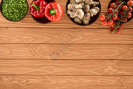 木板上碗中各种蔬菜的香蘑菇和菜类在图片