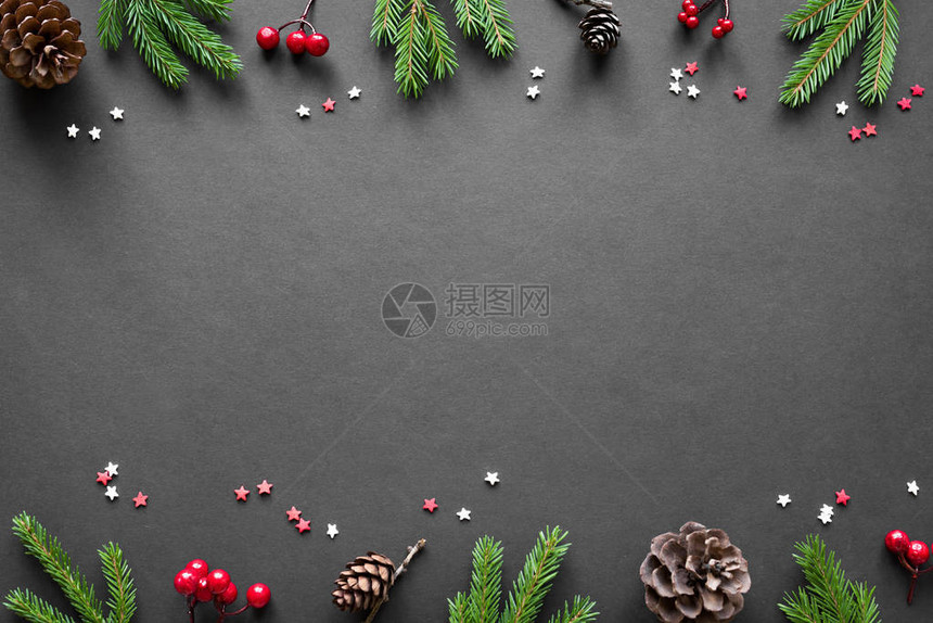 圣诞作文圣诞装饰松果冷杉树枝黑色背景上的红色浆果平躺图片