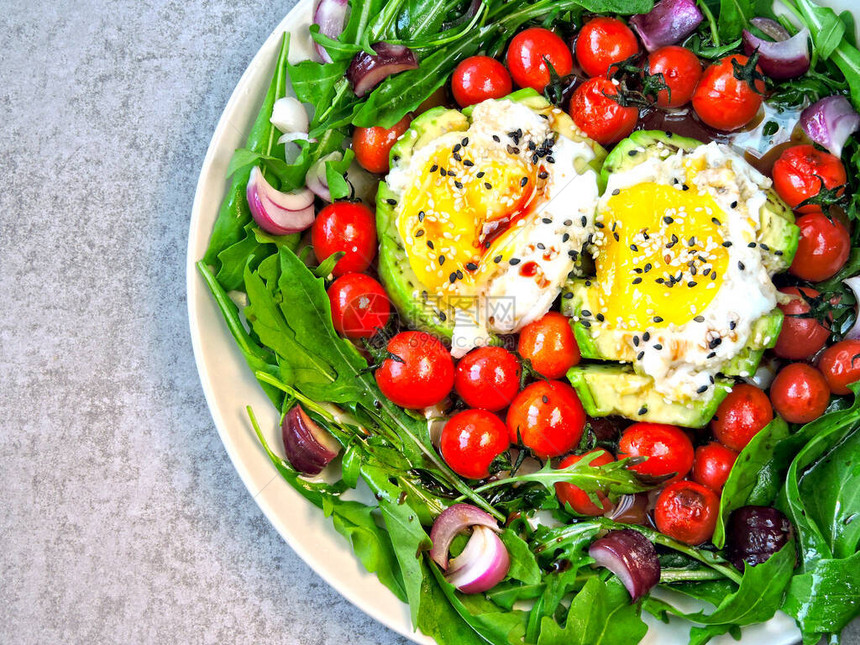 鳄梨配鸡蛋芝麻菜和樱桃番茄在盘子上盘子里有一顿健康的饭菜一份健康的沙拉图片