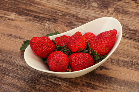 带叶的碗里成熟的甜草莓图片