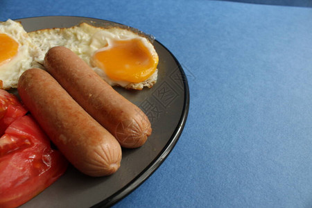 传统欧洲早餐鸡蛋香肠和沙拉蔬菜红西番茄图片